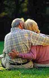man and woman sitting on grass and embracing