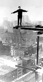 blindfolded man on girder of skyscraper