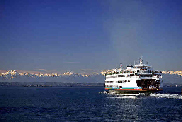 a seattle ferry and the snow-capped olympic mountains in the background