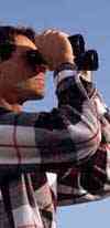 man looking through binoculars